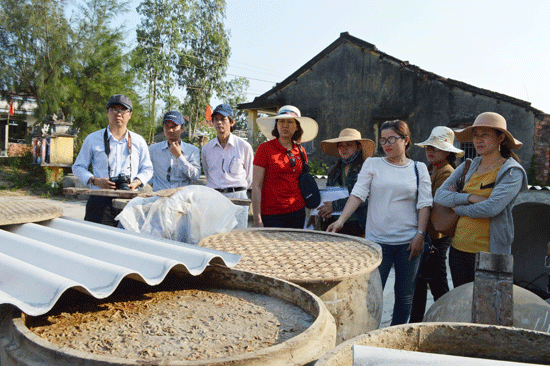 Du khách tìm hiểu nghề chế biến nước mắm của người dân vùng đông Duy Xuyên.Ảnh: V.LỘC