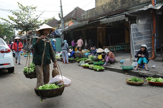 Từ sáng sớm, người quê gánh vài bó rau ra bán phiên chợ mở hàng đầu năm. Ảnh: MINH HẢI