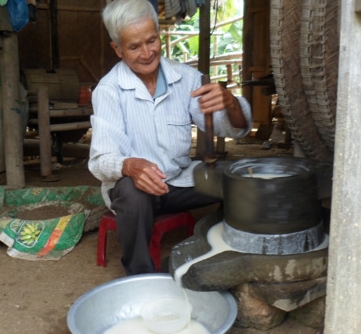 Cụ Nguyễn Bình với công đoạn chế biến rượu nếp theo kiểu thủ công. Ảnh: H.Yên