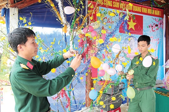 Cán bộ, chiến sĩ Trung đoàn 885 trang trí cành mai đón tết. Ảnh: TUẤN ANH