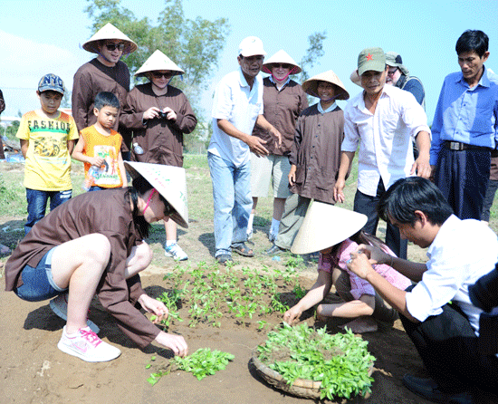 Du khách nước ngoài tham gia cuộc thi trồng rau tại lễ hội cầu Bông ở làng rau Trà Quế (xã Cẩm Hà, TP.Hội An). Ảnh: MINH HẢI