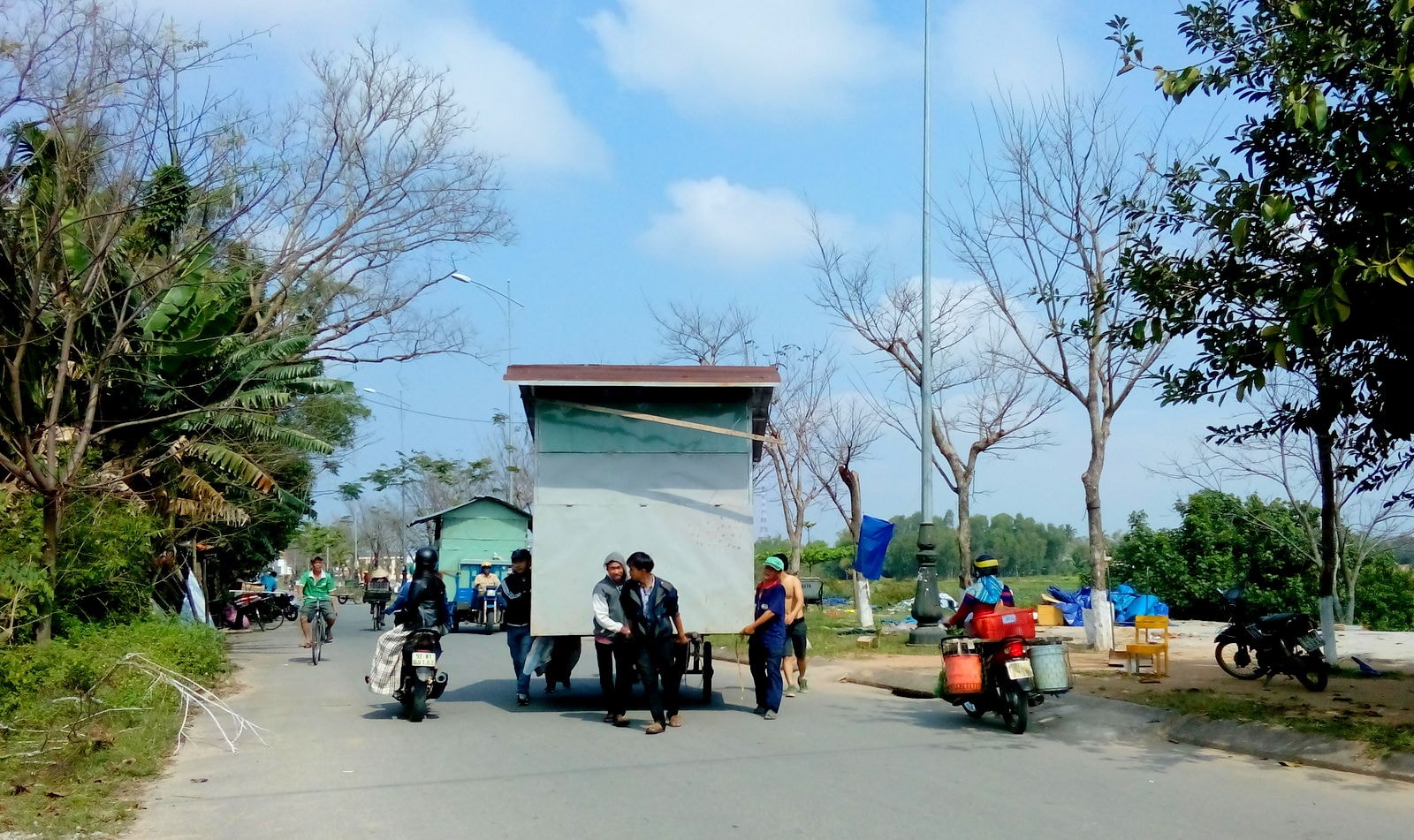 Các hộ dân di dời lều, trại, vật dụng che chắn để hoàn trả lại mặt bằng vỉa hè đường Bạch Đằng. Ảnh: XUÂN KHÁNH