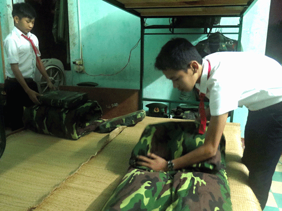 Hai em Khoa và Phi cẩn thận xếp chăn, màn mỗi buổi sáng tại Đồn Biên phòng Tam Thanh. 