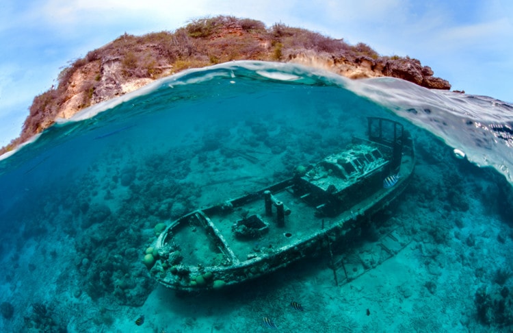 A Family Affair. Winner, International, Wrecks. I was unable to descend because I had to take care of Maja, my five year old daughter who is unable to snorkel by herself. So my only possibility was a shot from the surface. It was too rough for a normal over/under shot. I decided to try a wave & wreck shot with the island of Curacao in the background. All taken while swimming together with my daughter. I needed several tries to compose the wreck, the wave, and the island in one shot. But at the end I got this real over/under shot with a total view of the famous wreck. #  © UPY / Thomas Heckmann