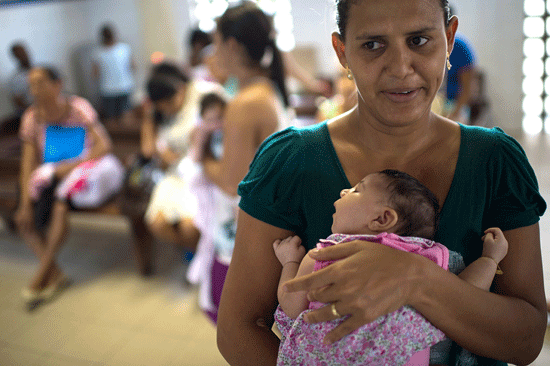 Một bà mẹ Brazil đưa con nhỏ đến trung tâm y tế địa phương để khám chữa bệnh. (Ảnh: ibtimes)
