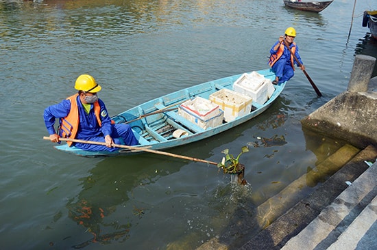 Thành viên tổ thu gom rác thải vớt rác trên sông Hoài.  Ảnh: QUỐC TUẤN