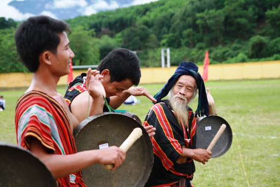 Già làng Hồ Văn Dinh (ngoài cùng bên phải) cùng các nghệ nhân huyện Bắc Trà My trình diễn điệu múa cồng chiêng truyền thống của dân tộc mình.  Ảnh: PHƯƠNG GIANG