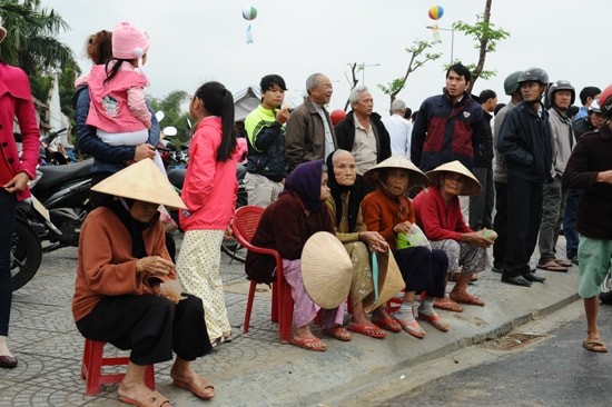 Những cụ bà đội mưa đến từ sáng sớm để chứng kiến lễ khánh thành chiếc cầu. Ảnh: MINH HẢI