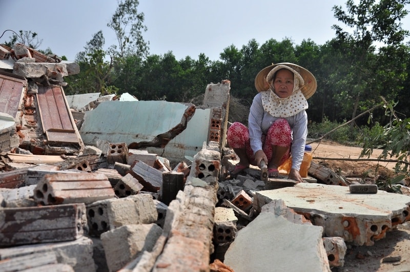 Trên nền nhà cũ của gia đình, người phụ nữ này đang cố gắng để tận dụng lại những viên gạch cũ