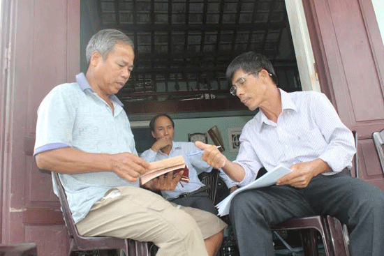 Ông Nguyễn Công Bá (phải) tranh thủ buổi trưa đi điều tra BHYT hộ gia đình.Ảnh: D.L