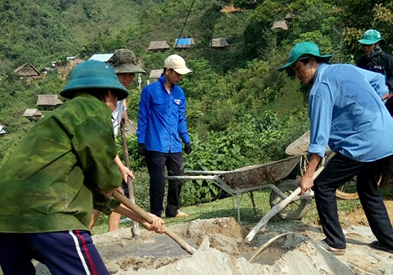 Đoàn viên Phân đoàn Tài chính kế hoạch - Ban Quản lý đầu tư xây dựng huyện Nam Trà My cùng người dân đổ bê tông con đường lên nóc Măng Lưng. Ảnh: MINH NGHĨA