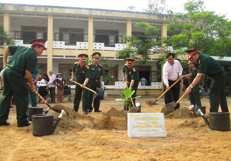 Trung tướng Lê Chiêm cùng lãnh đạo các đơn vị trồng cây lưu niệm tại Trường THCS Quế Phong. Ảnh: H.N