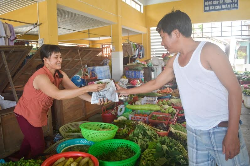 Tiểu thương chợ Tân Hiệp gói thực phẩm bằng túi giấy. Ảnh: TAM CA