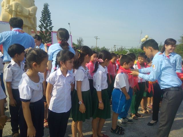 Nghi thức trao khăn quàng đỏ cho các em đội viên mới. Ảnh: MỸ LINH