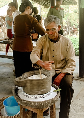 Trình diễn xay bột bằng cối đá tại Vinahouse (Điện Bàn). Ảnh: THÀNH CÔNG