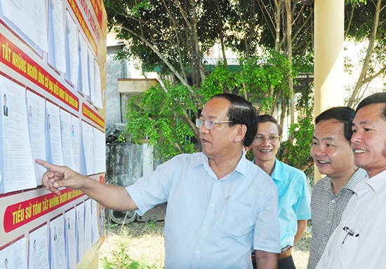 Chủ tịch UBND tỉnh Đinh Văn Thu - Chủ tịch Ủy ban Bầu cử tỉnh kiểm tra việc niêm yết tóm tắt tiểu sử ứng cử viên tại khu vực bỏ phiếu số 1, thôn Chiêm Sơn, xã Duy Trinh (Duy Xuyên). Ảnh: HÀN GIANG