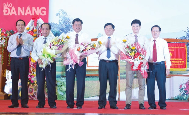 Lãnh đạo thành phố và huyện Hòa vang tặng hoa lãnh đạo Bộ NN&PTNT và Văn phòng điều phối xây dựng nông thôn mới Trung ương, nhân dịp huyện Hòa Vang đón nhận Bằng công nhận huyện đạt chuẩn nông thôn mới của Chính phủ. Ảnh: NGUYỄN CẦU