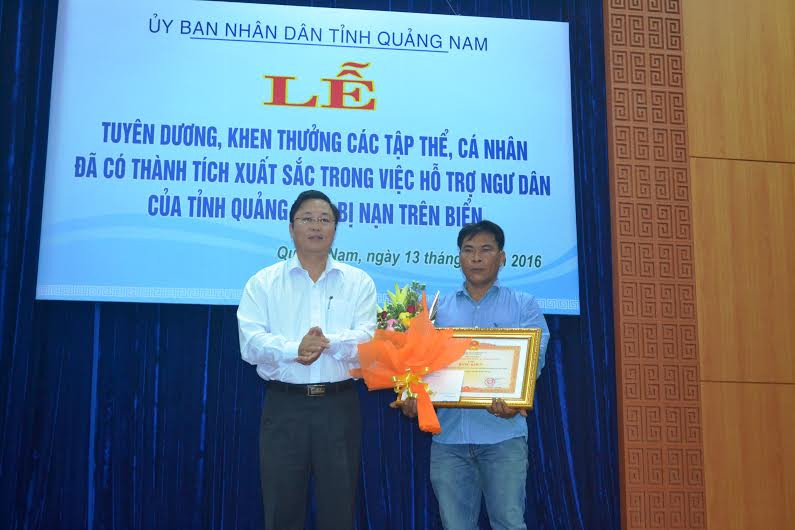 Phó Chủ tịch UBND tỉnh Lê Trí Thanh trao tặng Bằng khen của Thủ tướng khen tặng thuyền trưởng và các thuyền viên trên tàu cá QNa-94998. Ảnh: Q.V 