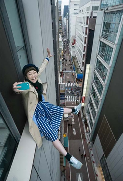 Ngồi trên gờ cửa sổ tầng lầu ở Tokyo chụp ảnh “tự sướng”