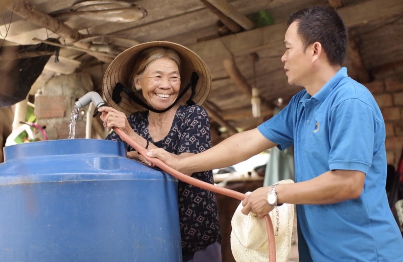 Người dân phấn khởi vì được tặng nước sạch. Ảnh: A.Đ