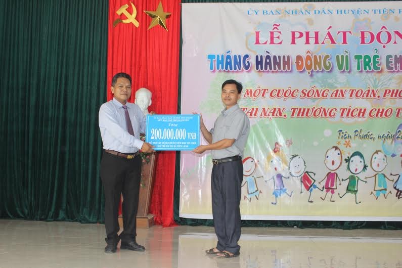 Ông Phùng Văn Huy - Phó Chủ tịch UBND huyện Tiên Phước trao 200 triệu đồng xây dựng khu vui chơi cho trẻ em xã Tiên Lãnh. Ảnh: D.L