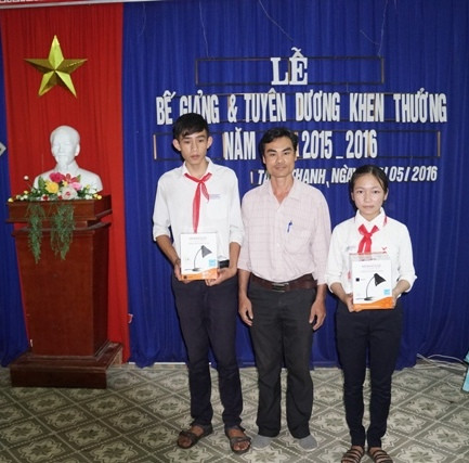 Ông Phạm Phú Hiển - Giám đốc Công ty TNHH TM-DV Phú Hiển Lighting trao quà cho học sinh Trường THCS Thái Phiên (Tam Kỳ). ảnh: Điện Ngọc.