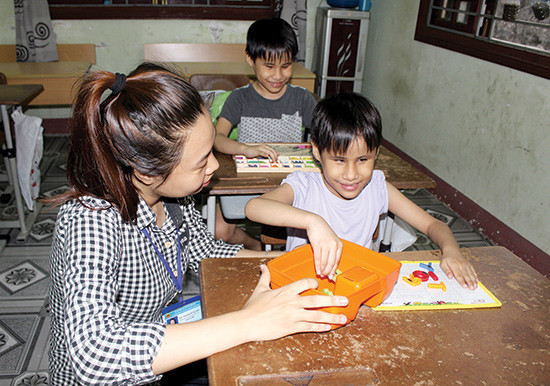 Hai bé Yến Vi và Á Vi học chữ nổi tại Trung tâm Nuôi dưỡng trẻ em mồ côi và tàn tật xã hội Hội An. Ảnh: D.LỆ
