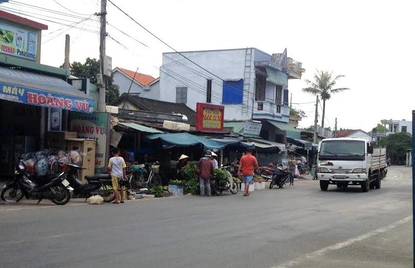 Gần nửa phần đường Quốc lộ đang là nơi họp chợ của người dân.