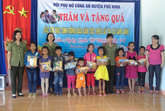 Phụ nữ Công an huyện Phú Ninh tặng quà cho trẻ em đồng bào dân tộc tại xã Tam Lãnh. Ảnh: T.A