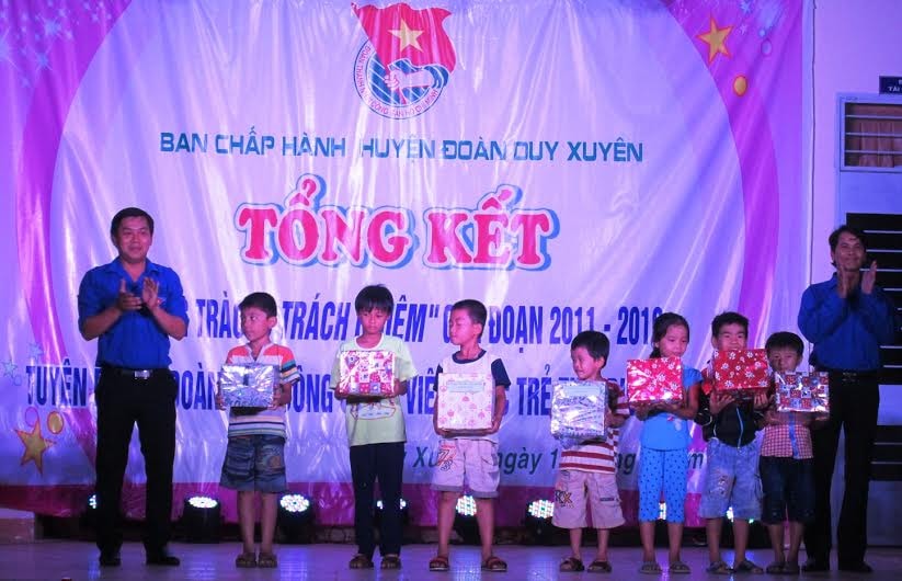 Tặng quà cho các em học sinh nghèo vượt khó học giỏi tại buổi lễ. Ảnh: HOÀI NHI