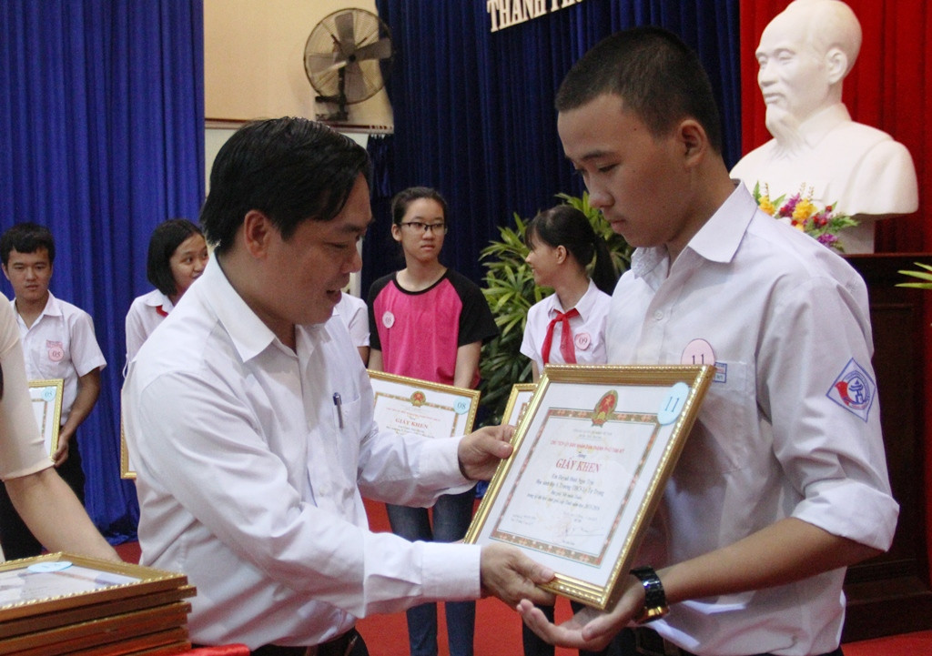 Phó Chủ tịch UBND TP.Tam Kỳ Trần Ngọc Ảnh trao giấy khen cho các em học sinh giỏi, có thành tích cao trong học tập. Ảnh: A.N