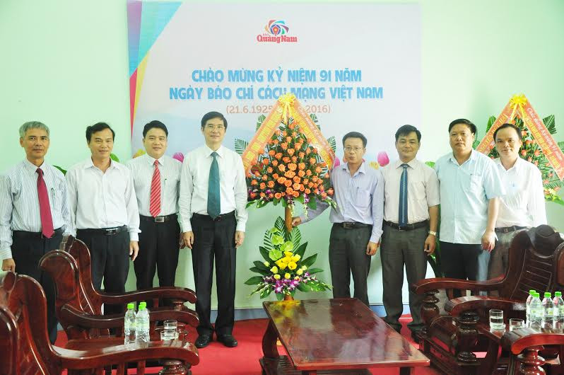 Bí thư Tỉnh ủy Nguyễn Ngọc Quang tặng hoa, chụp hình lưu niệm với cán bộ lãnh đạo Báo Quảng Nam. 