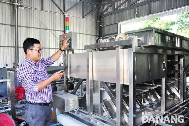 Kỹ sư Nguyễn Thành Chương vận hành máy phân cỡ tôm điện tử trước khi giao cho doanh nghiệp. Ảnh: Thanh Tình