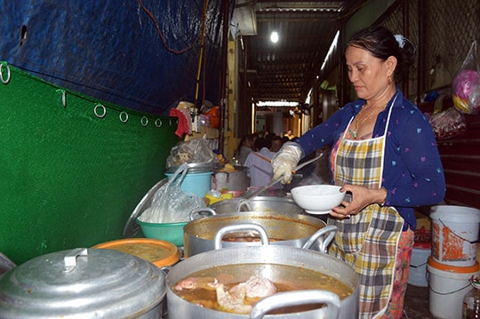 Bà Quýt bên gian bếp banh canh của mình. Ảnh: K.LINH