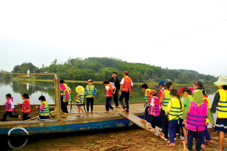 Trẻ em xã miền núi Tam Trà (Núi Thành) đến trường an toàn hơn với những chiếc áo phao do các anh chị thanh niên trao tặng. Ảnh: PHAN TUẤN