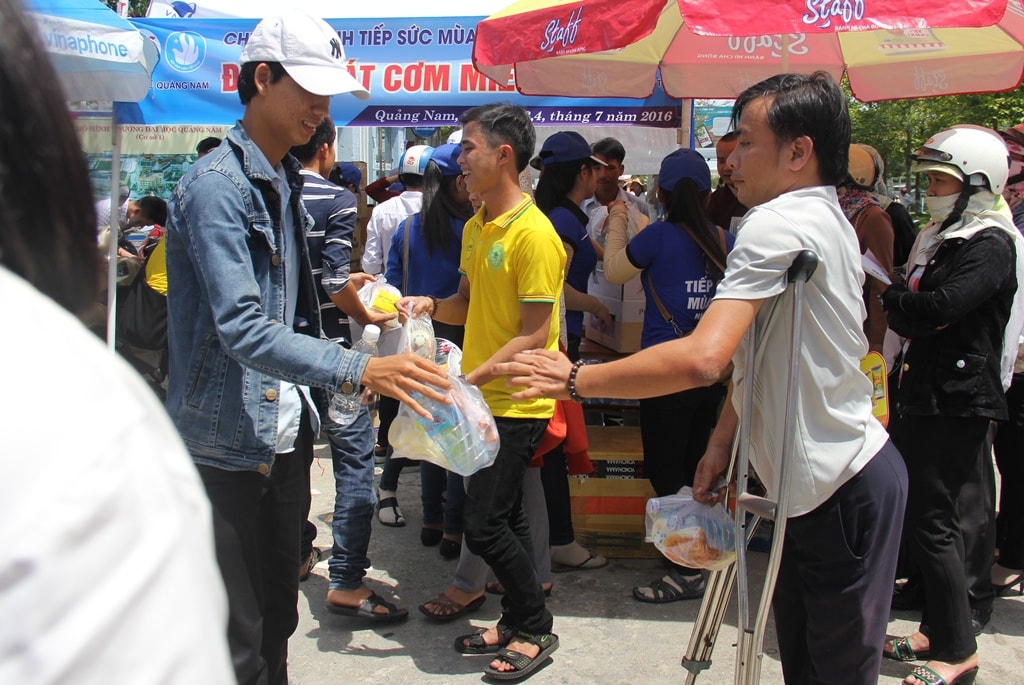 Anh Quang đội nắng phát các suất cơm co thí sinh. Ảnh: ALĂNG NGƯỚC