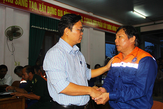 Phó Chủ tịch UBND tỉnh Lê Trí Thanh động viên ngư dân Phạm Phú Thành khi trở về đất liền sau tai nạn bị đâm chìm tàu.