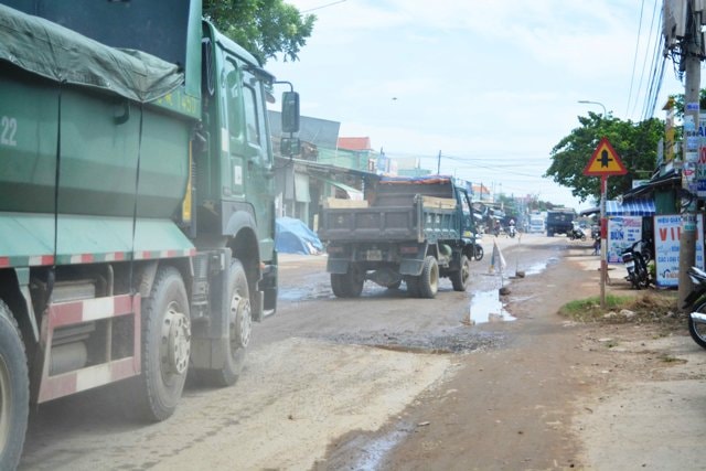 Đàn xe tải bị mắc kẹt khi người dân dựng rào chắn. Ảnh: Triêu Nhan