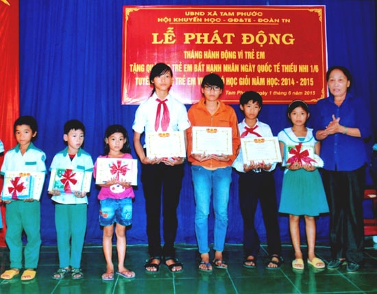 Bà Trương Thị Hường ở thôn Kỳ Phú, xã Tam Phước (Phú Ninh) trao học bổng khuyến học cho con em địa phương.