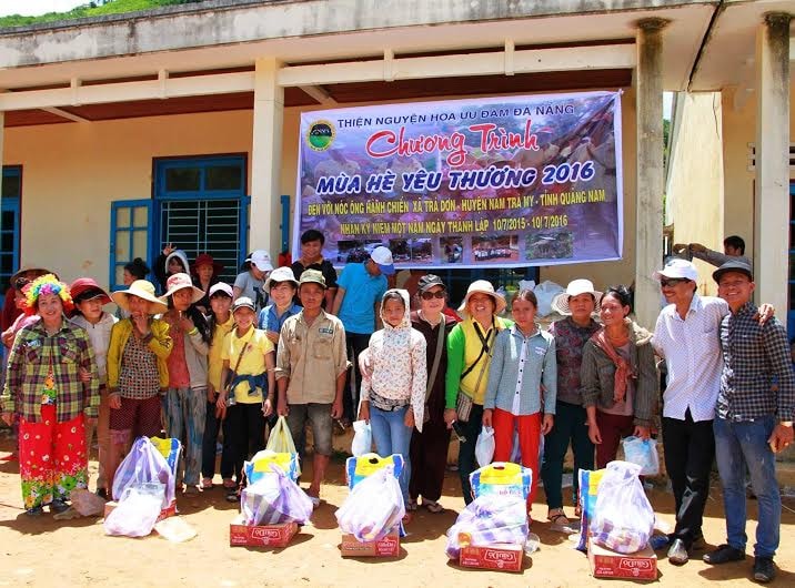 Các thành viên trong nhóm tặng quà cho những hộ nghèo ở nóc ông Hành Chiến.