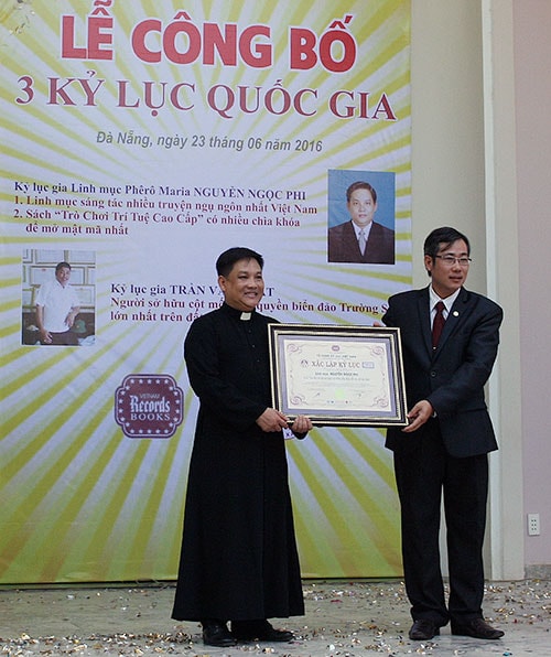 Linh mục Nguyễn Ngọc Phi nhận Bằng chứng nhận xác lập kỷ lục quốc gia từ đại diện Vietkings. Ảnh: SƠN TRUNG