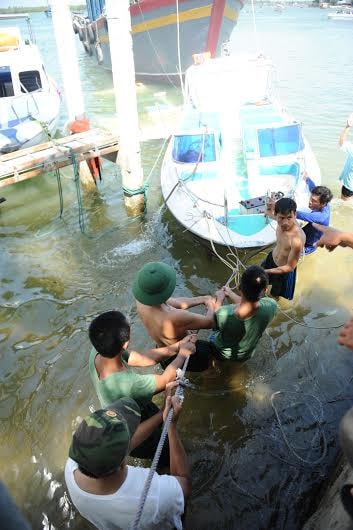 Nỗ lực đưa từng chiếc vào bờ. Ảnh: MINH HẢI