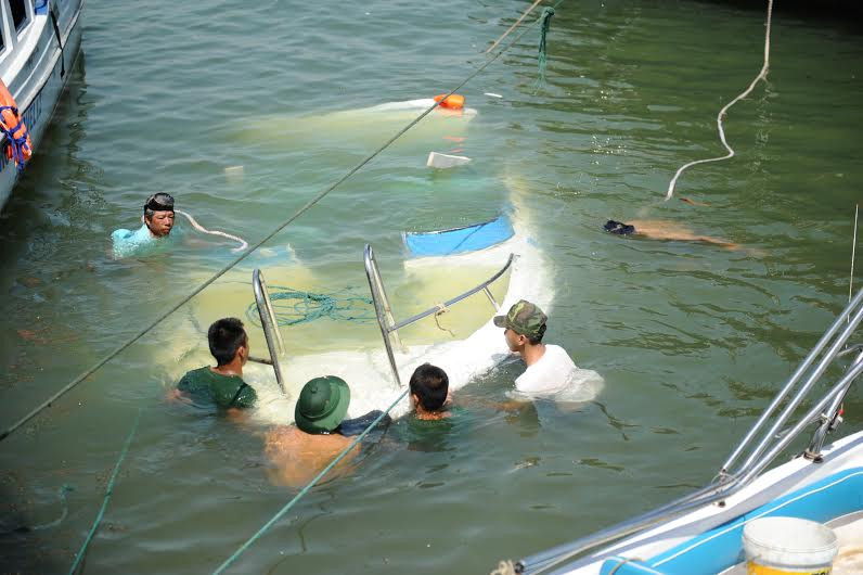 Lực lượng Biên phòng Cửa Đại và Hải đội II lặng để  buộc dây đưa ca nô lên khỏi mặt nước.
