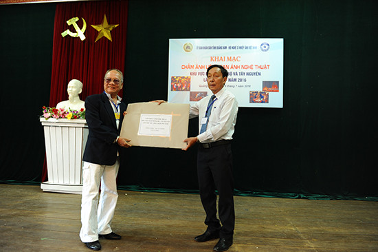 Trưởng Ban tổ chức liên hoan Nguyễn Hoàng Bích trao các tác phẩm cho trưởng Ban GK, NSNA Đồng Đức Thành. Ảnh: MINH HẢI
