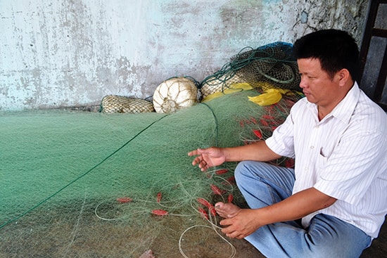 Ngư dân Trần Công Mậu chuẩn bị ra khơi làm tài công cho chủ tàu khác.Ảnh: QUANG VIỆT