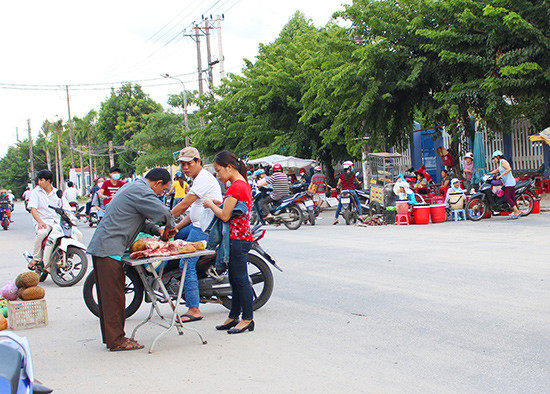 Thực phẩm bày bán ngay trên đường, đoạn trước các công ty may thuộc phường Trường Xuân, TP.Tam Kỳ. (Ảnh chụp chiều ngày 6.8.2016).  Ảnh: VĂN HÀO