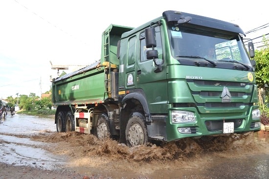 Mỗi lần xe tải chạy qua là nước bắn lên tung tóe. Ảnh: CÔNG TÚ