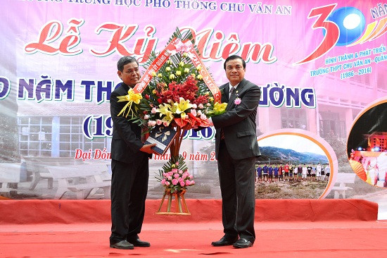 Đồng chí Phan Việt Cường tặng hoa chúc mừng nhà trường. Ảnh: K.KHIÊM
