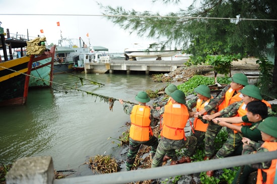 Cán bộ, chiến sĩ Đồn Biên phòng Cửa Đại giúp ngư dân neo đậu tàu thuyền. Ảnh: MINH HẢI