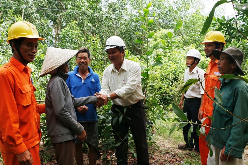 Các cán bộ Phòng An toàn – Công ty Điện lực Quảng Nam thuyết phục để người dân đồng ý cho chặt các cây gây mất an toàn hành lang lưới điện. (ẢNH: Đ.ĐẠO)